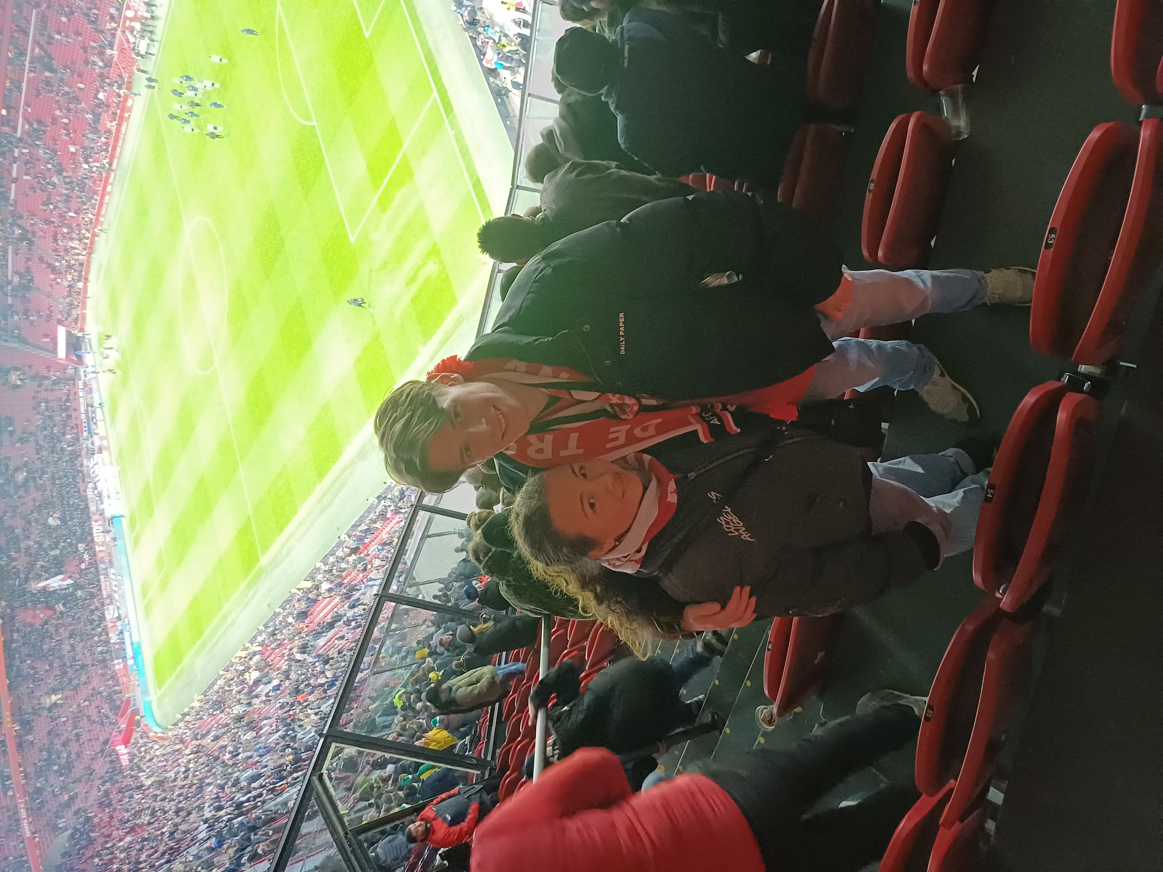 Wedstrijdafbeelding Ajax-Fortuna fotostaand van Lars en vriendin Lars met de veld en fans in de achtergrond.
